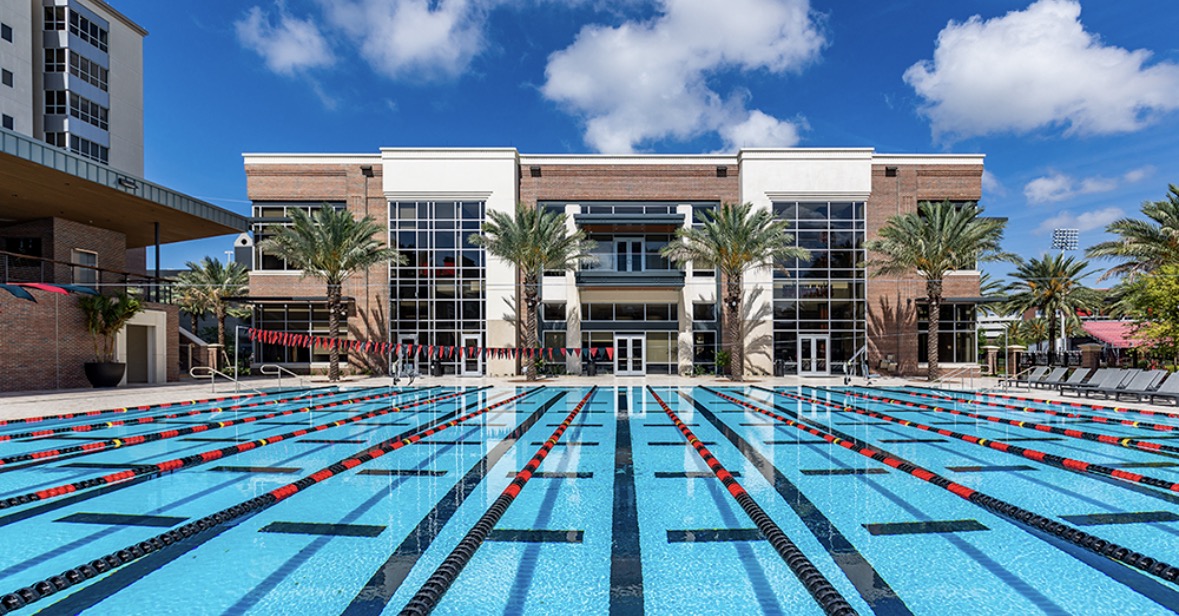 Outdoor campus aquatic center with a multi-lane pool and athletic building
