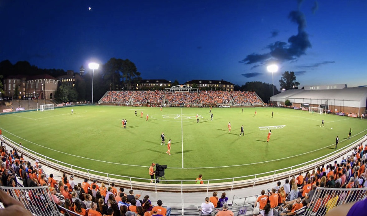 Clemson soccer stadium lit up at night during a match with a packed crowd